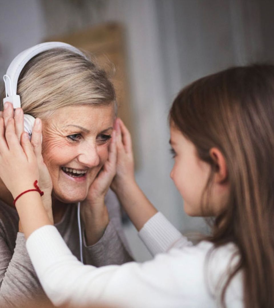 Grandchild helping grandmother to hear